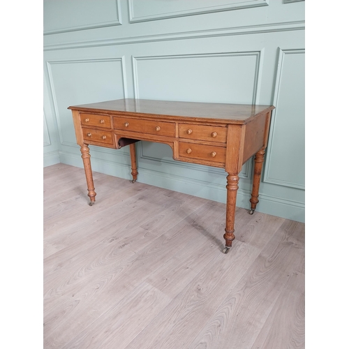 1218 - 19th C. Howard & Sons oak desk raised on turned legs and brass castors {76 cm H x 122 cm W x 60 cm D... 