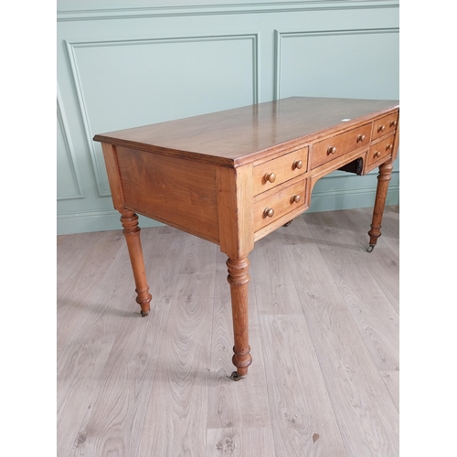 1218 - 19th C. Howard & Sons oak desk raised on turned legs and brass castors {76 cm H x 122 cm W x 60 cm D... 