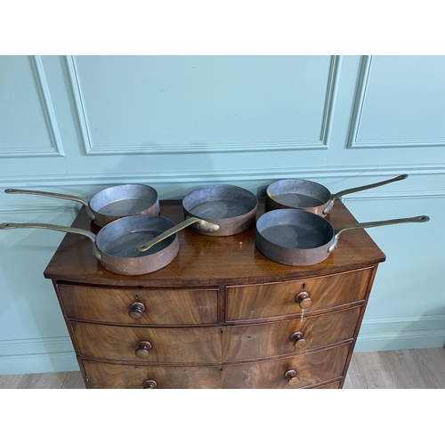 1331 - Collection of five copper saucepans with brass handles {Approx. 11 cm H x 58 cm W x 28 cm D}.