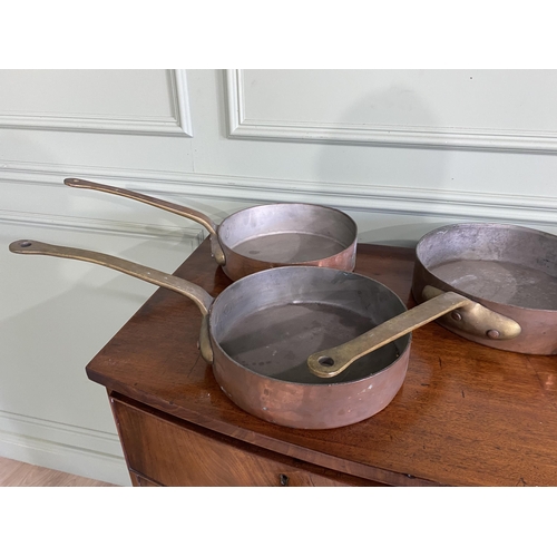 1331 - Collection of five copper saucepans with brass handles {Approx. 11 cm H x 58 cm W x 28 cm D}.