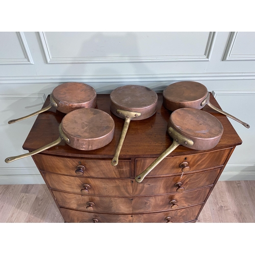 1331 - Collection of five copper saucepans with brass handles {Approx. 11 cm H x 58 cm W x 28 cm D}.