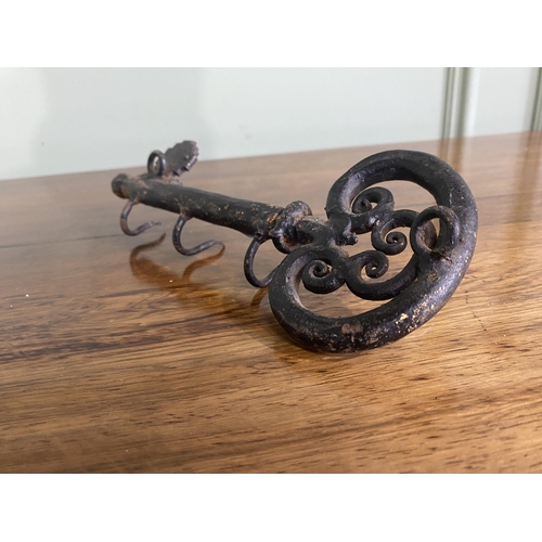 1333 - Unusual wrought iron wall-mounted key hanger in the form of a key {9 cm H x 23 cm W x 6 cm D}.