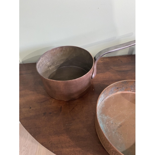 195 - Three early 20th C. heavy copper saucepans with wrought iron handles {18 cm H x 47 cm W x 22 cm D an... 