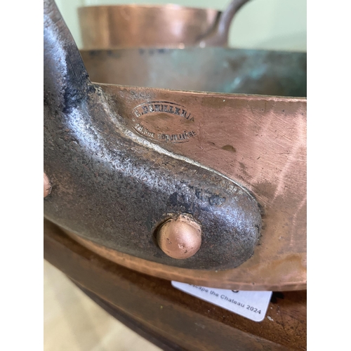 195 - Three early 20th C. heavy copper saucepans with wrought iron handles {18 cm H x 47 cm W x 22 cm D an... 