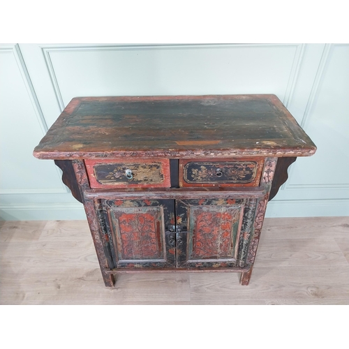 196 - Oriental painted hardwood side cabinet with two short drawers over two blind doors raised on square ... 