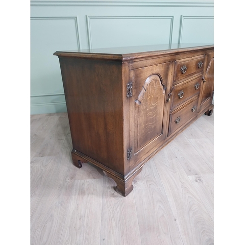 197 - Good quality oak side cabinet with three drawers flanked by two blind doors raised on bracket feet i... 