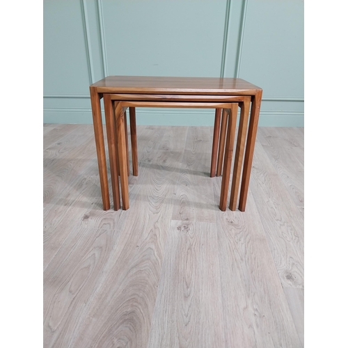 22 - Mid-century teak nest of three tables raised on square legs {52 cm H x 64 cm W x 39 cm D}.