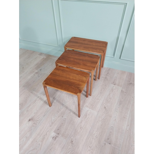 22 - Mid-century teak nest of three tables raised on square legs {52 cm H x 64 cm W x 39 cm D}.