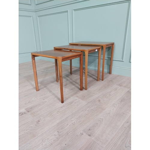 22 - Mid-century teak nest of three tables raised on square legs {52 cm H x 64 cm W x 39 cm D}.