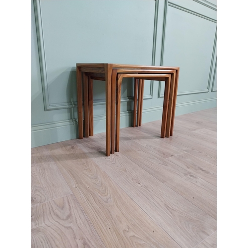 22 - Mid-century teak nest of three tables raised on square legs {52 cm H x 64 cm W x 39 cm D}.