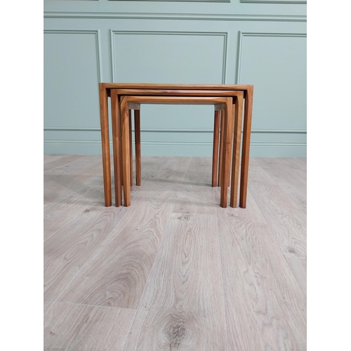 22 - Mid-century teak nest of three tables raised on square legs {52 cm H x 64 cm W x 39 cm D}.