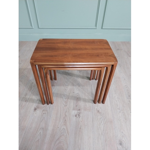 22 - Mid-century teak nest of three tables raised on square legs {52 cm H x 64 cm W x 39 cm D}.