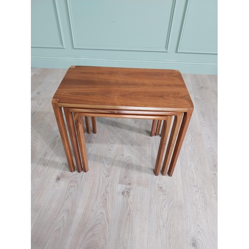 22 - Mid-century teak nest of three tables raised on square legs {52 cm H x 64 cm W x 39 cm D}.