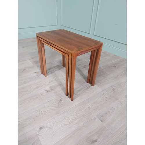 22 - Mid-century teak nest of three tables raised on square legs {52 cm H x 64 cm W x 39 cm D}.