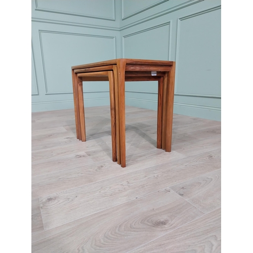 22 - Mid-century teak nest of three tables raised on square legs {52 cm H x 64 cm W x 39 cm D}.