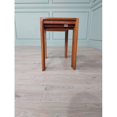 22 - Mid-century teak nest of three tables raised on square legs {52 cm H x 64 cm W x 39 cm D}.