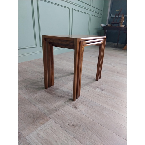 22 - Mid-century teak nest of three tables raised on square legs {52 cm H x 64 cm W x 39 cm D}.