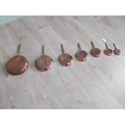 3 - Set of seven copper saucepans with brass handles {43 cm H x 23 cm W and 20 cm H x 9 cm W}.