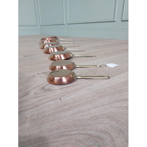 3 - Set of seven copper saucepans with brass handles {43 cm H x 23 cm W and 20 cm H x 9 cm W}.