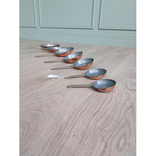 3 - Set of seven copper saucepans with brass handles {43 cm H x 23 cm W and 20 cm H x 9 cm W}.