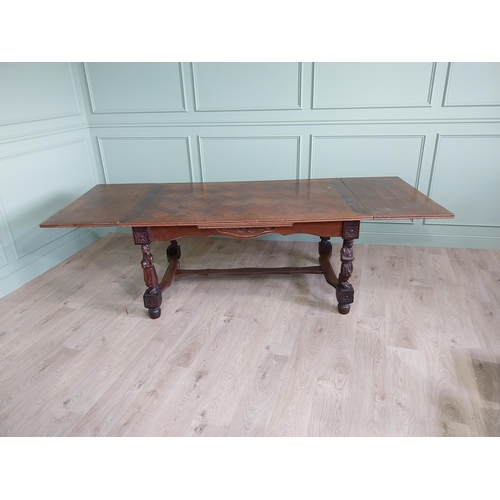 388 - Edwardian oak drawer leaf dining table raised on carved legs and single stretcher {78 cm H x 106 cm ... 