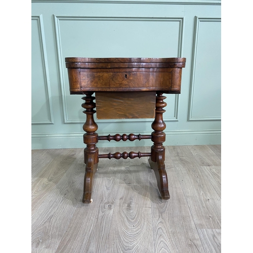 421 - Victorian burr walnut games and sewing table raised on turned legs, single stretcher and castors {72... 