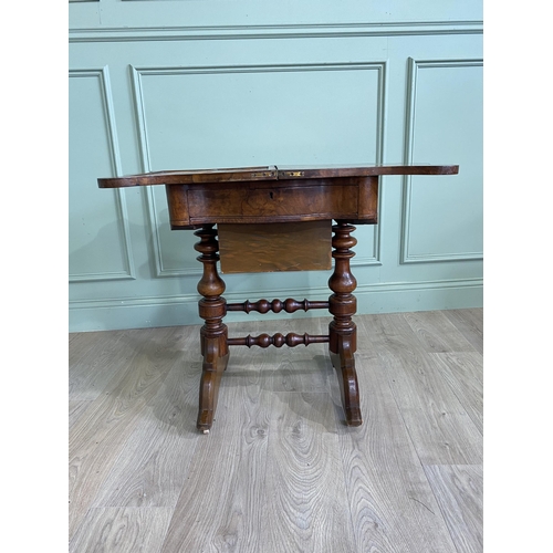 421 - Victorian burr walnut games and sewing table raised on turned legs, single stretcher and castors {72... 