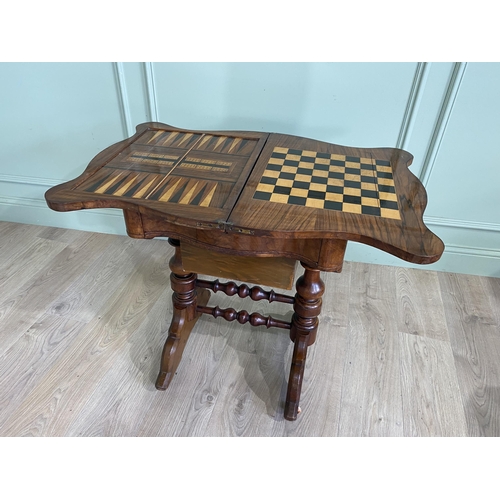 421 - Victorian burr walnut games and sewing table raised on turned legs, single stretcher and castors {72... 