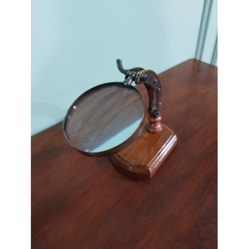 54 - Brass desk magnifying glass mounted on scumble pine base {18 cm H x 23 cm W x 10 cm D}.