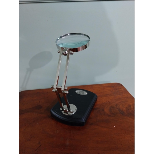 706 - Chrome desk magnifying lamp mounted on ebonised base {22 cm H x 13 cm W x 18 cm D}.