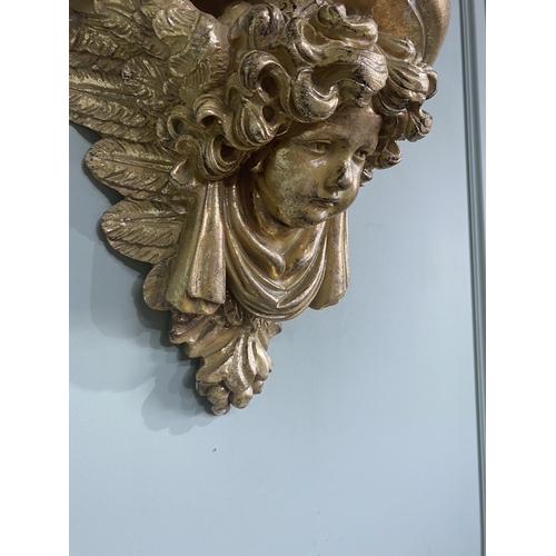 75 - Pair of gilded resin wall sconces decorated with winged cherubs {30 cm H x 32 cm W x 20 cm D}.