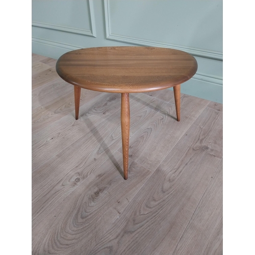 761 - Ercol oak lamp table raised on three splayed legs {36 cm H x 56 cm W x 38 cm D}.