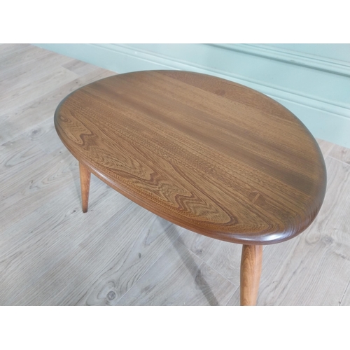 761 - Ercol oak lamp table raised on three splayed legs {36 cm H x 56 cm W x 38 cm D}.