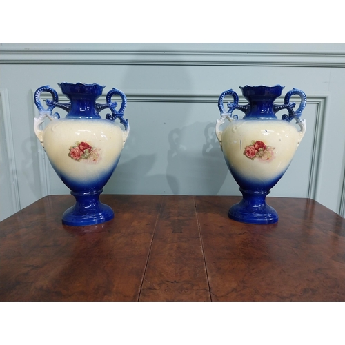 877 - Pair of ceramic vases with floral design and gilt handles {35 cm H x 24 cm W x 15 cm D}.