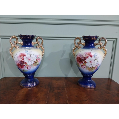 877 - Pair of ceramic vases with floral design and gilt handles {35 cm H x 24 cm W x 15 cm D}.