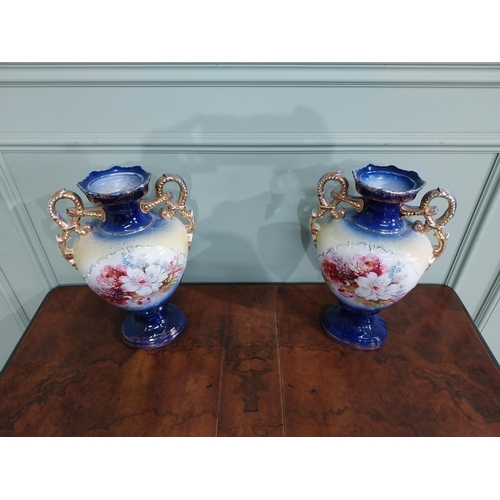 877 - Pair of ceramic vases with floral design and gilt handles {35 cm H x 24 cm W x 15 cm D}.