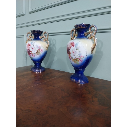 877 - Pair of ceramic vases with floral design and gilt handles {35 cm H x 24 cm W x 15 cm D}.