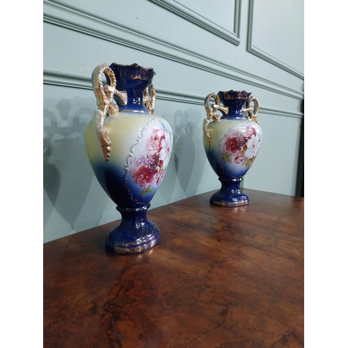 877 - Pair of ceramic vases with floral design and gilt handles {35 cm H x 24 cm W x 15 cm D}.