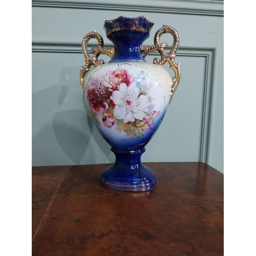 877 - Pair of ceramic vases with floral design and gilt handles {35 cm H x 24 cm W x 15 cm D}.