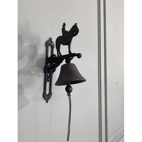 934 - Decorative cast iron wall mounted bell surmounted with horse and rider {37 cm H x 14 cm W x 25 cm D}... 