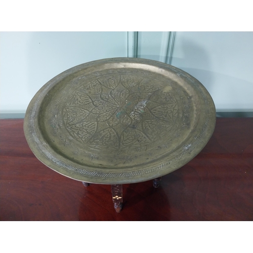 94 - Unusual early 20th C. Middle Eastern coffee table with embossed brass top and folding hardwood stand... 