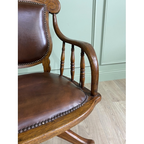 867 - Edwardian oak revolving office chair with leather upholstered seat {91 cm H x 56 cm W x 62 cm D}.