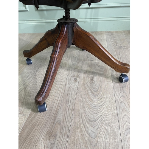 867 - Edwardian oak revolving office chair with leather upholstered seat {91 cm H x 56 cm W x 62 cm D}.