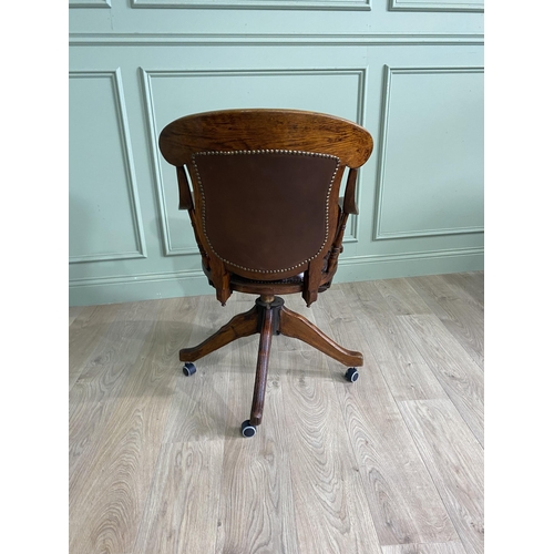 867 - Edwardian oak revolving office chair with leather upholstered seat {91 cm H x 56 cm W x 62 cm D}.