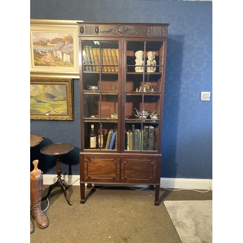 25 - Edwardian mahogany two door display cabinet above two blind doors raised on square tapered legs in t... 