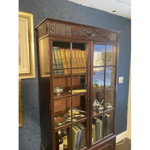 25 - Edwardian mahogany two door display cabinet above two blind doors raised on square tapered legs in t... 