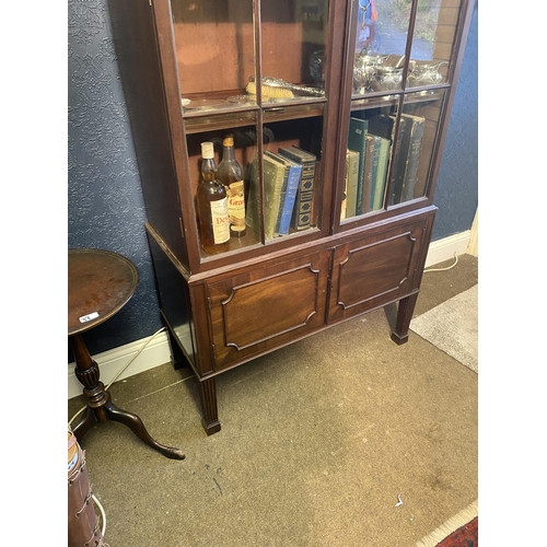 25 - Edwardian mahogany two door display cabinet above two blind doors raised on square tapered legs in t... 