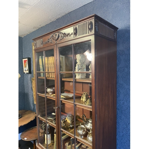 25 - Edwardian mahogany two door display cabinet above two blind doors raised on square tapered legs in t... 