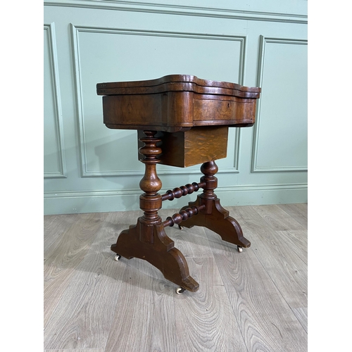 480 - Victorian burr walnut games and sewing table raised on turned legs, single stretcher and castors {72... 