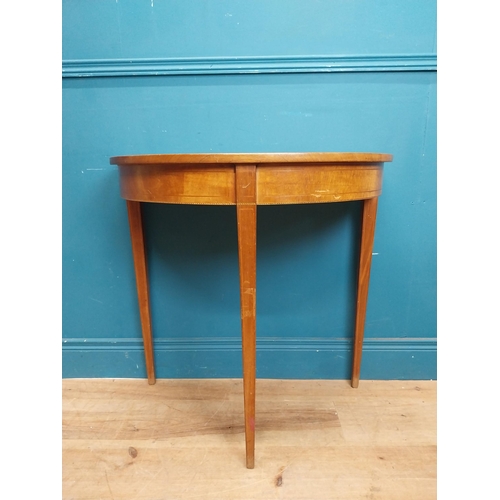 281 - Mahogany and satinwood demi lune table on three tapered feet. {74 cm H x 76 cm W x 41 cm}.